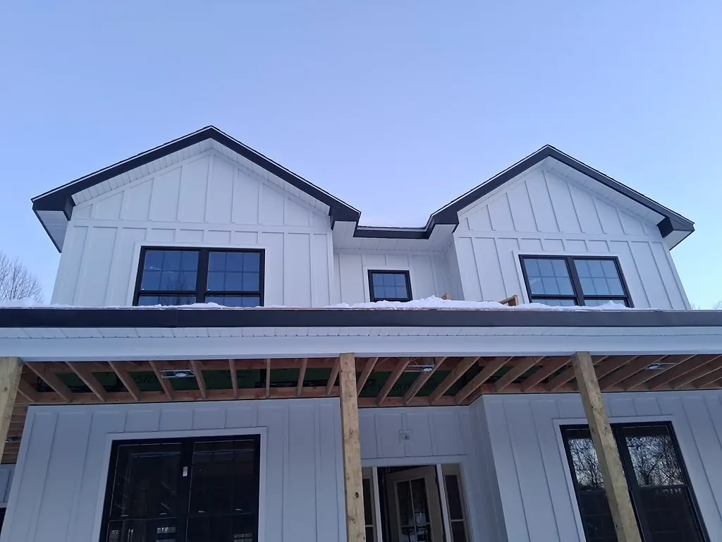 Completed white board and batten siding on a modern farmhouse with dual gables