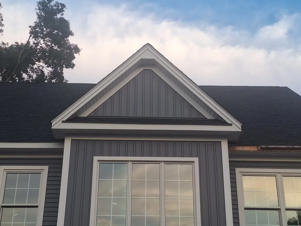 Architectural gable pediment detail with board and batten siding and white trim