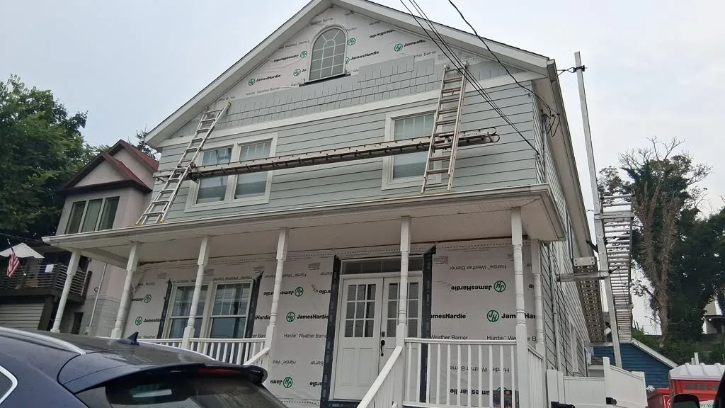 Fiber cement siding installation on a home with a covered front porch